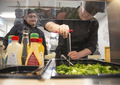 Cafe Kiipula toimii myös opiskelijoiden oppimisympäristönä. Opiskelija ottaa näytettä ruoasta työhönvalmentajan seuratessa työskentelyä.