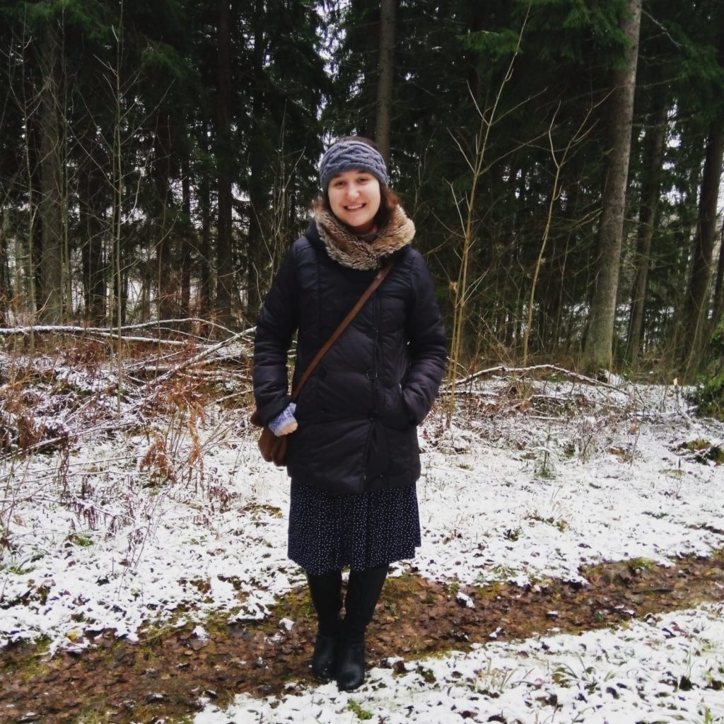 Annaïg seisoo lumisessa metsässä. 