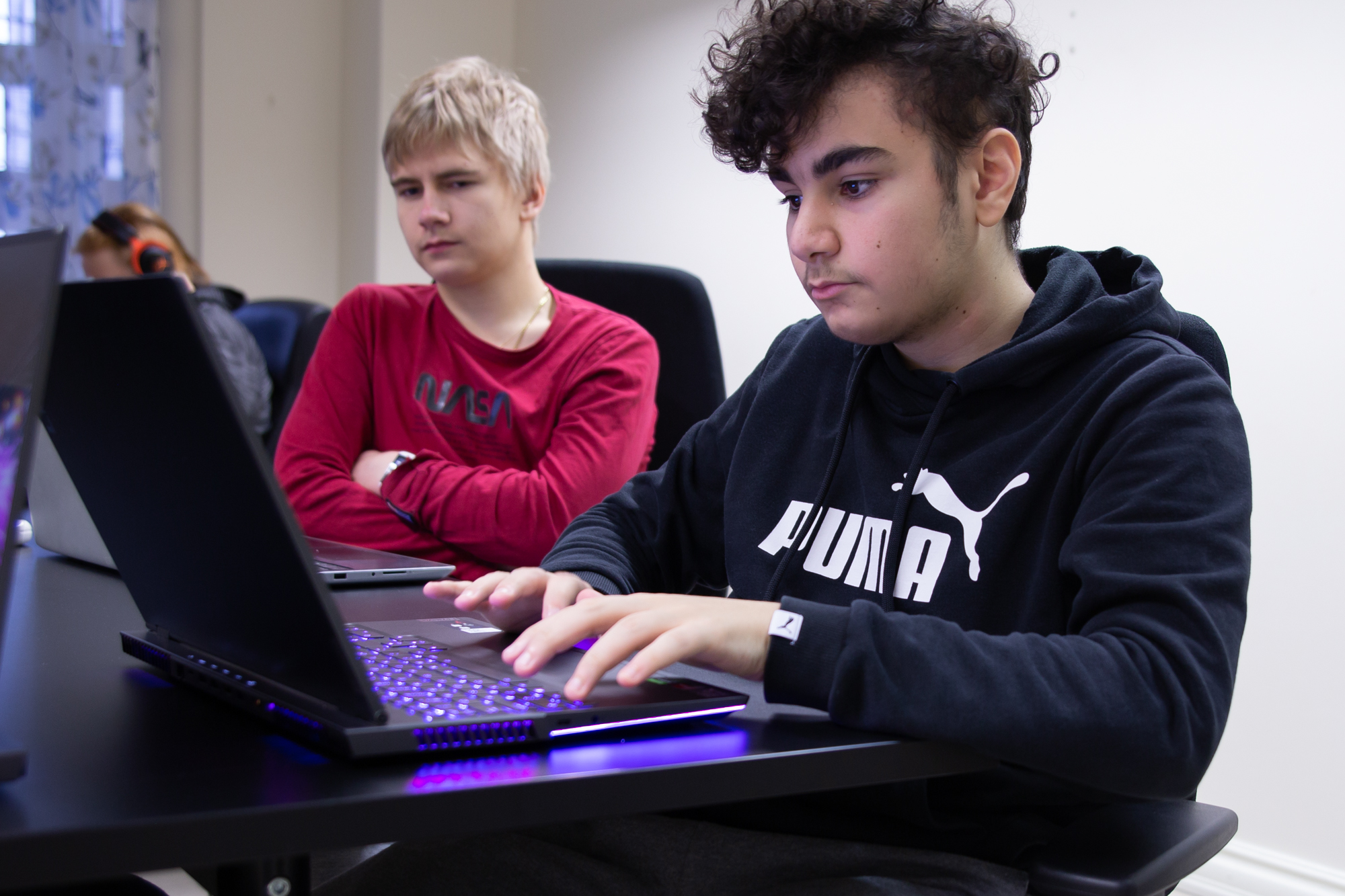 Kaksi poikaa tietokoneiden äärellä.
