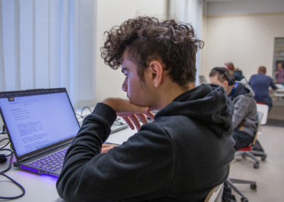 Opiskelija kannettavan tietokoneen äärellä.