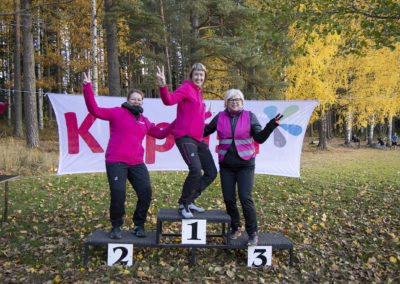 Kolme tapahtuman järjestäjä naista poseeraamassa KiipMTB-tapahtuman palkintokorokkeella.
